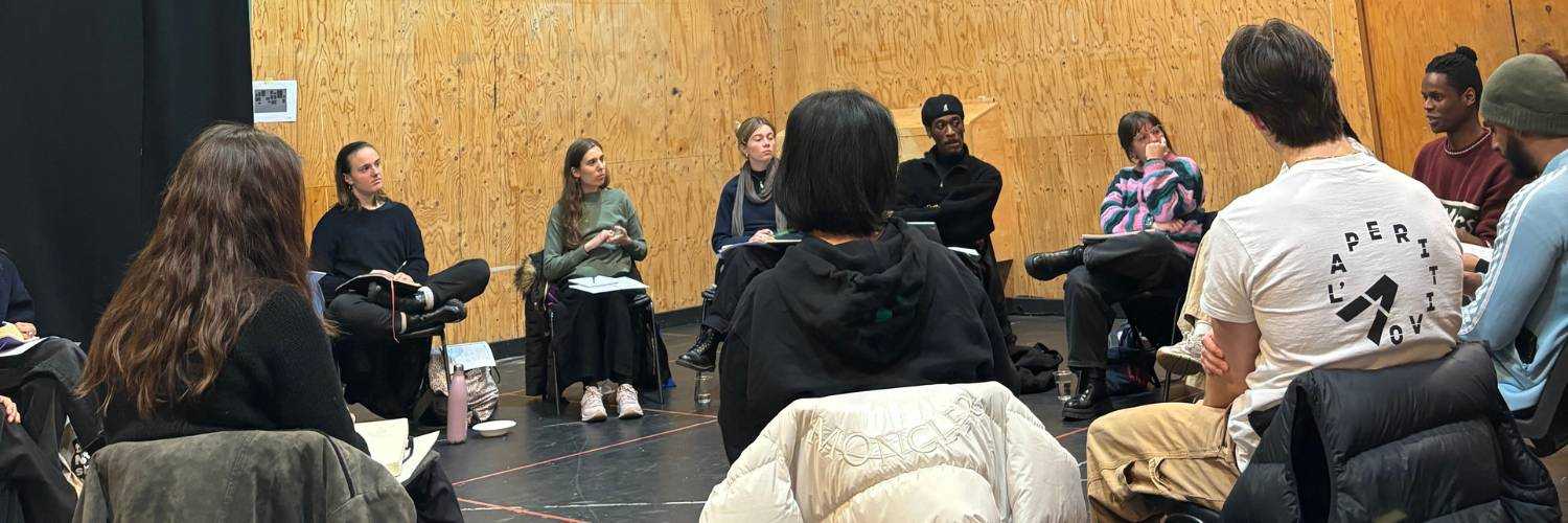 Young people in a workshop sat in a drama studio