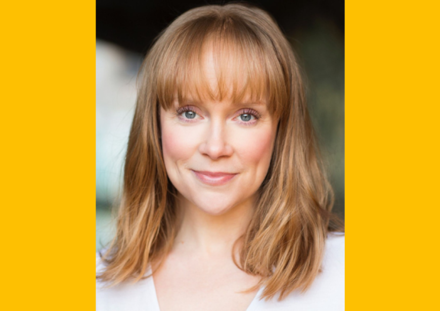 A headshot of a person with blonde hair with a full fringe wearing a white top. 