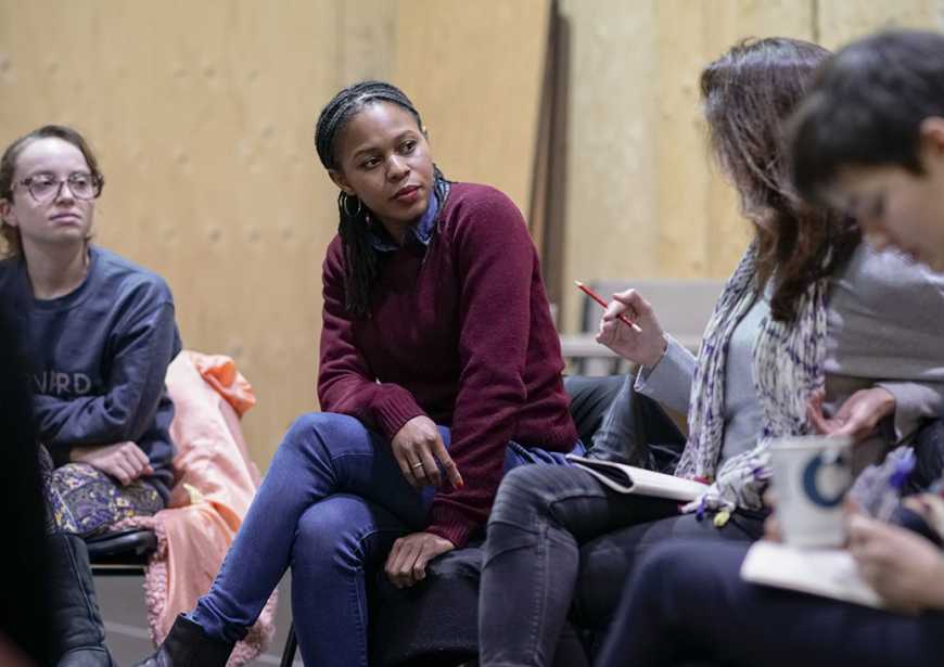 Nicole Charles, Assistant Director on The Jungle at the Young Vic, listening to a production chat back attendee.