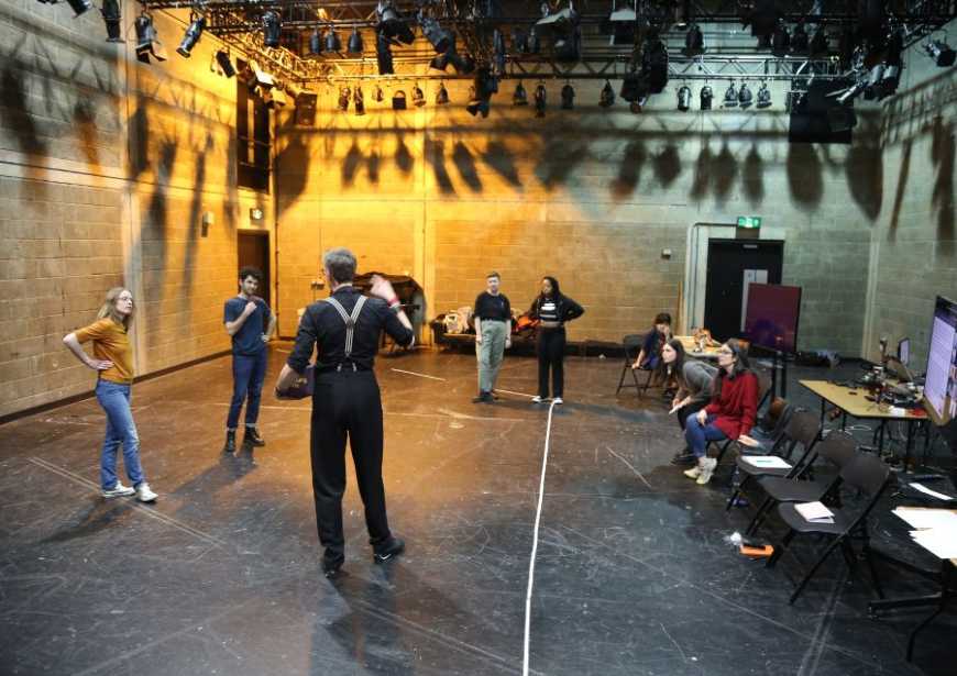 A group of people stood and sat in a studio space for a workshop