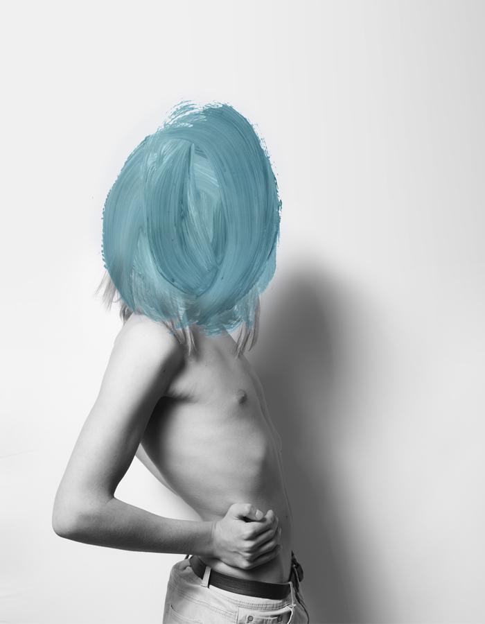 A black and white image of an androgynous person wearing jeans and no top stands side on to the camera. Their face is not visible - the image has thick brush strokes of turquoise paint covering from their shoulders up. Their long blonde hair is just visible beneath the edges of the brush strokes.