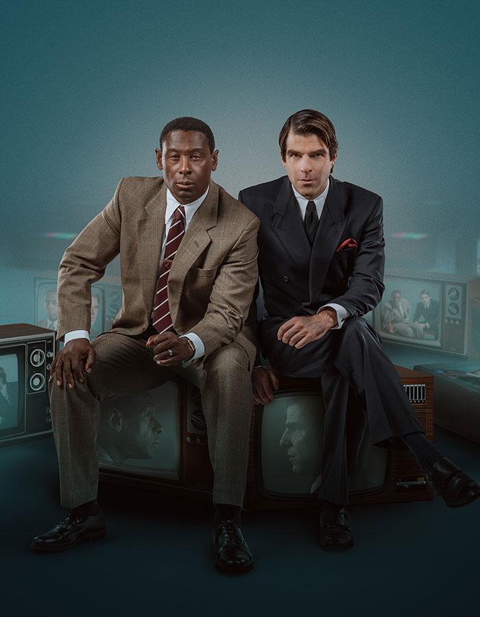 Best of Enemies West End. From 14th November 2022 to 18th February 2023. Image description: Two men in suits, sat side by side, on a number of TVs with their faces on the screen. The words "Best of Enemies' are in white in the center right of the image. 
