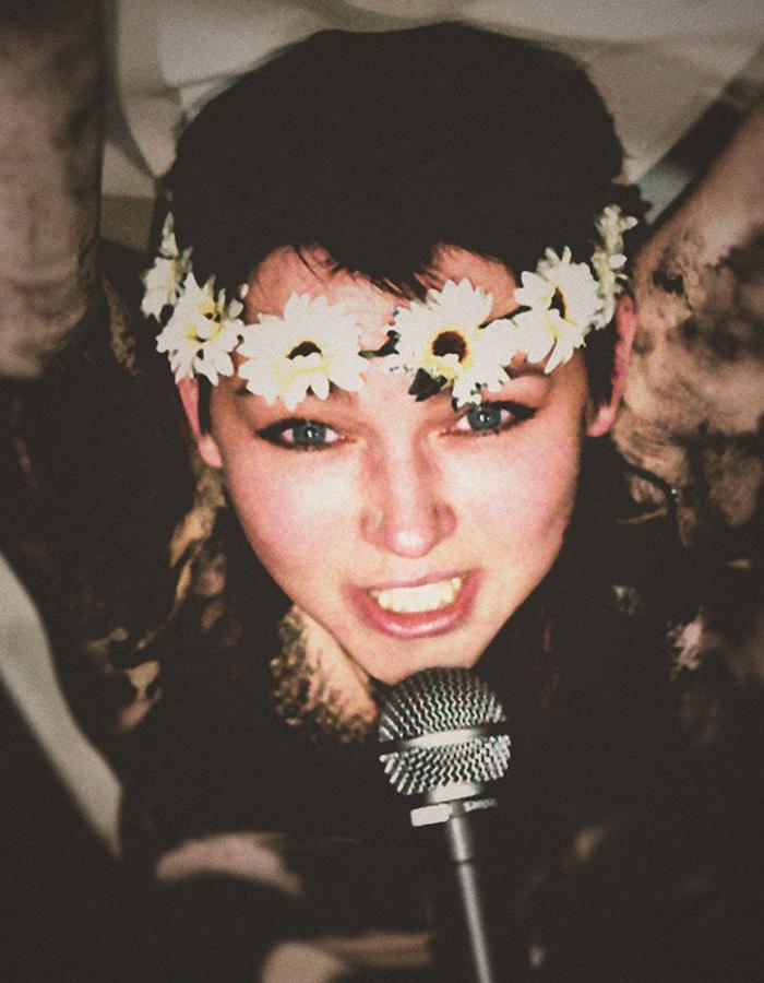 A girl with a flowered headband talks into a microphone