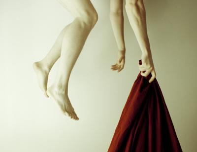 A red shawl being held from the hand a suspended being